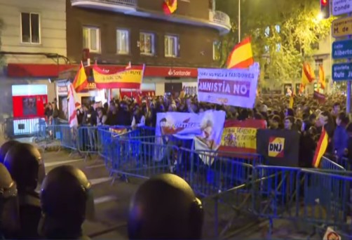 Grupo de fascistas con banderas de España, frente a Ferraz, detrás de unas vallas azules 