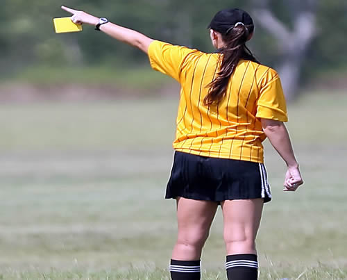 Arbitra en el terreno de juego enseñando tarjeta amarilla